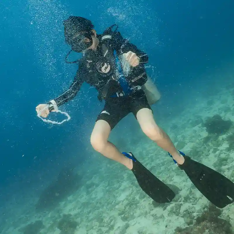 Breath Control and Bubble Rings in Koh Tao Diver creating bubble rings while practising breath control during a PADI Peak Performance Buoyancy course in Koh Tao