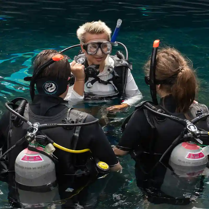 PADI Discover Scuba Diving Pool Training in Koh Tao Flow Divers instructor helping beginners during PADI Discover Scuba Diving pool training in Koh Tao