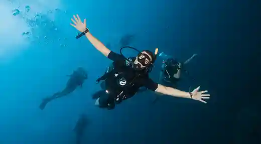 Happy diver underwater in Koh Tao Happy scuba diver underwater in Koh Tao with arms outstretched during a fun dive