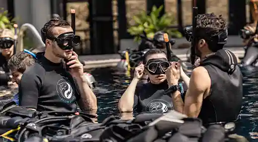 PADI Open Water Pool Training in Koh Tao Three divers in a training pool during a PADI Open Water lesson in Koh Tao