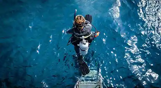 PADI Enriched Air Nitrox Course in Koh Tao Scuba diver swimming beside a large school of fish in Koh Tao