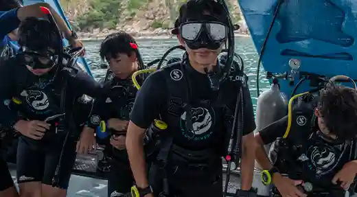 Nitrox Divers Ready for the Water Group of divers preparing their equipment aboard the Flow Divers boat in Koh Tao