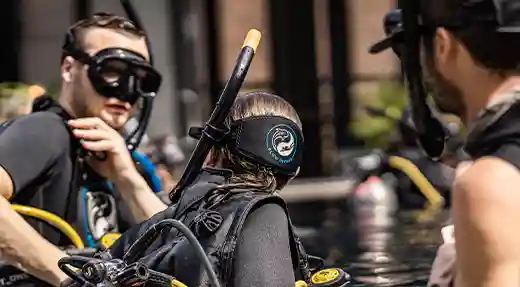 PADI Rescue Diver Course and EFR in Koh Tao Diving instructor helping a student with scuba equipment during PADI Rescue Diver Course and EFR training in Koh Tao
