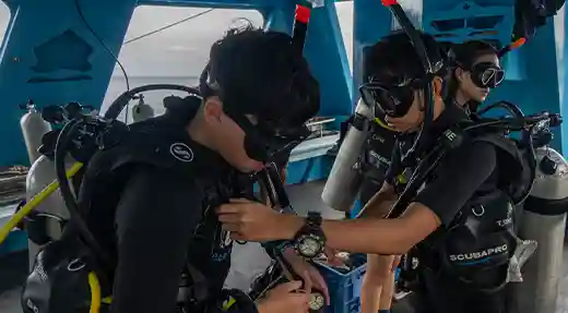 PADI Scuba Diver Buddy Check in Koh Tao Students completing a buddy equipment check before a PADI Scuba Diver training dive in Koh Tao