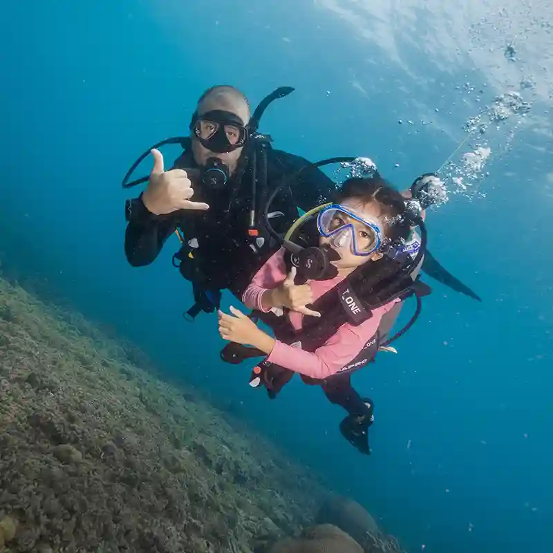 PADI Bubblemaker First Ocean Dive in Koh Tao Child scuba diving with a PADI Professional during a shallow Bubblemaker ocean dive in Koh Tao.